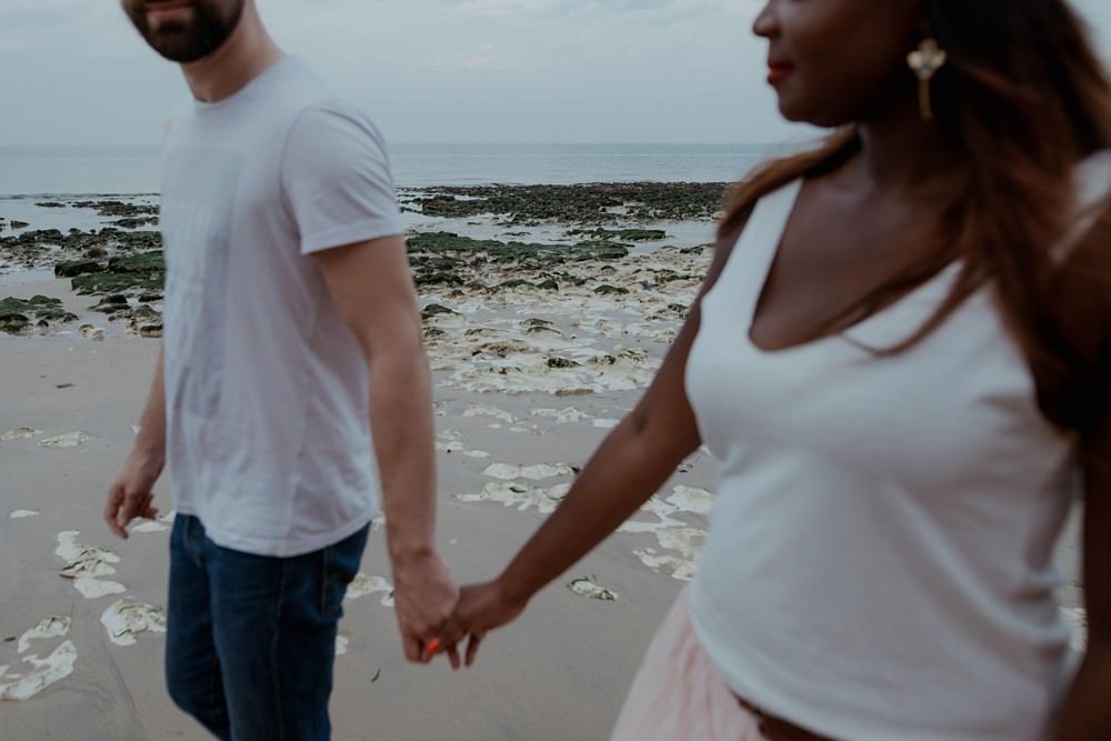 Séance photo en couple avant le mariage (shooting engagement) sur la plage de Dieppe à marée basse par Emmanuelle Auzou photographe à Dieppe
